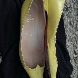 Yellow Christian Louboutin flat wing tips